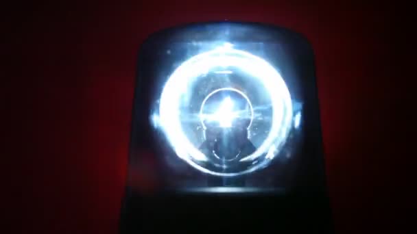 Flasher tourne rapidement dans l'obscurité et illumine le mur derrière lui avec une lumière vive 
