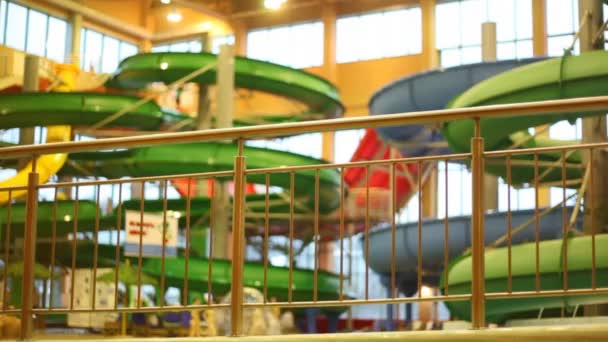 Pool with fountain is located behind metal fence in water park — Stock Video