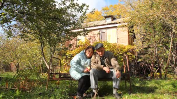 Aged woman sits with aged smoking man — Stock Video