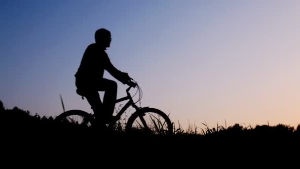 Silhouette eines Mannes, der Fahrrad fährt, stoppt gegen den Himmel — Stockvideo