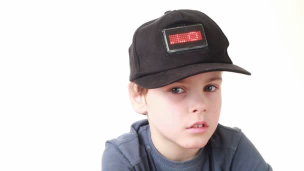 Niño en gorra con palabra Hola en rojo led pantalla aflige — Vídeo de stock