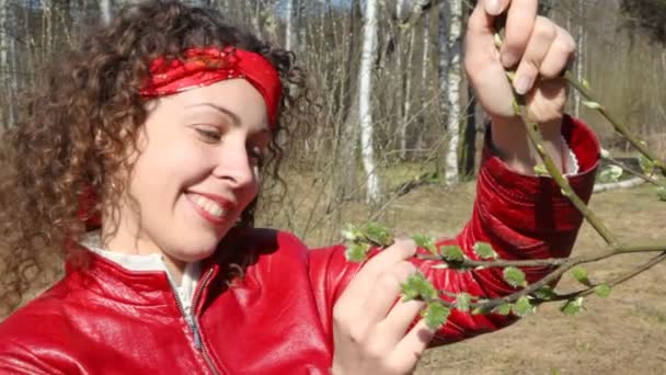 Szczęśliwa młoda kobieta opisz oddział z pąkami liści w lesie, wiosna — Wideo stockowe