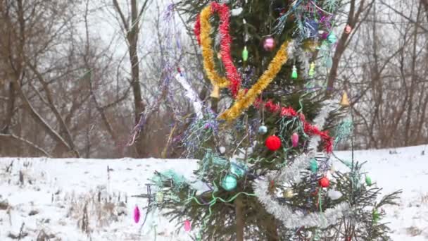 Kar yağışı sırasında açık bir şekilde dekore edilmiş Noel ağacı — Stok video