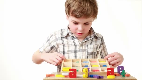 Boy raises box with cells containing figures and shows equation — Stock Video