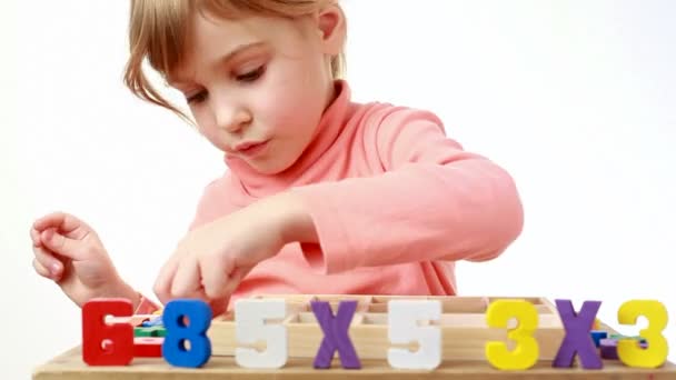 女孩把木制彩色数字放在以单元格框中 — 图库视频影像