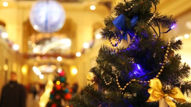 Close up New Year's tree with blinking dark blue garlands in shopping centre — Stock Video