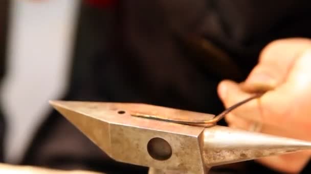 Hammer knocks on heated slice of iron on an anvil, forming it — Stock Video