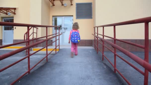 Girl comes to door of apartment block and using entrance door intercom — Stock Video