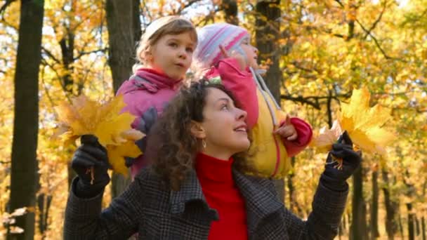 Donna con foglie e ragazze nel parco — Video Stock