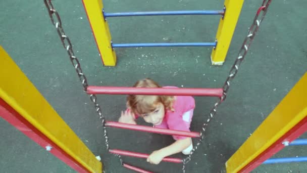 Девушка взбирается по цепной лестнице — стоковое видео