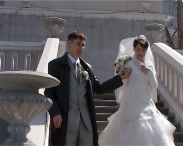 Bridegroom holds hand bride and leads her down the stairs — Stock Video