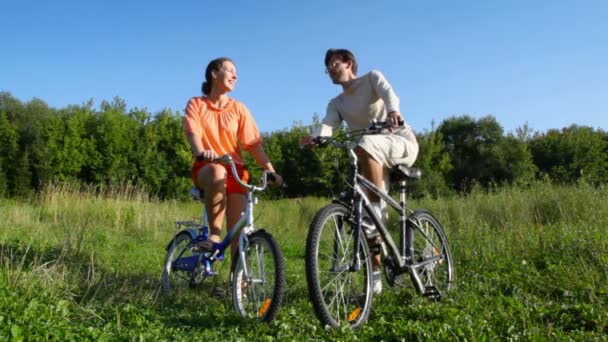 Pareja en bicicletas conversaciones en el campo — Vídeos de Stock
