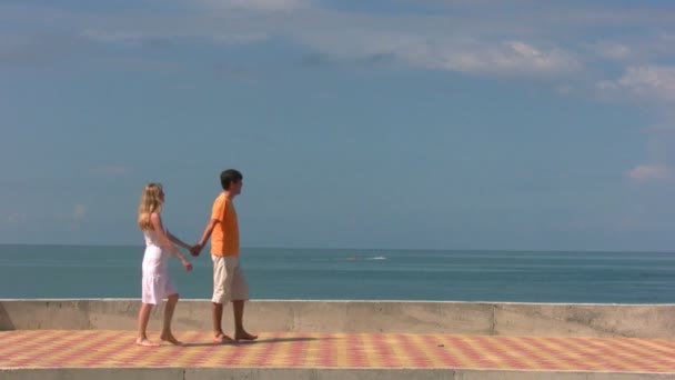 Couple promenades, puis l'homme tient femme regarde la mer avec cutter — Video