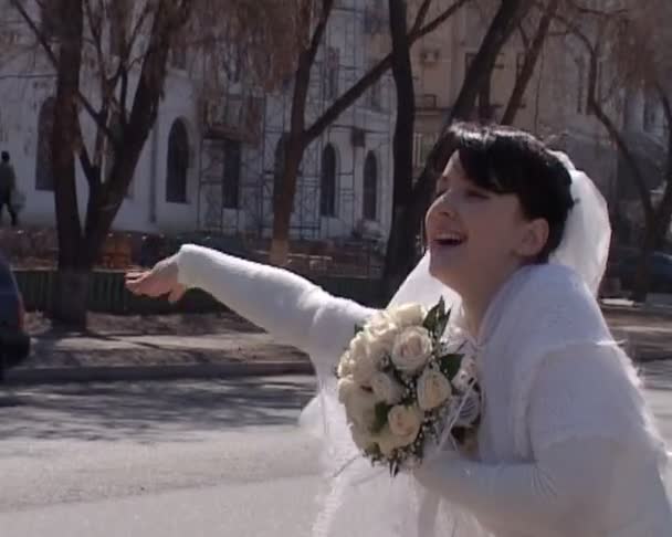 Heureuse mariée agitant vers le bas se tient sur la rue de la ville — Video