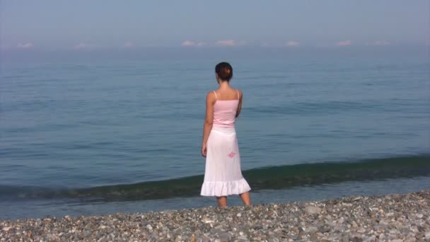 Woman in transparent skirt stands on beach — Stock Video