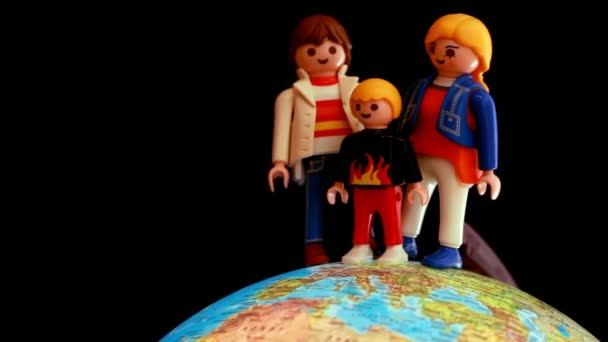 Família de brinquedos está localizada em um globo rotativo — Vídeo de Stock