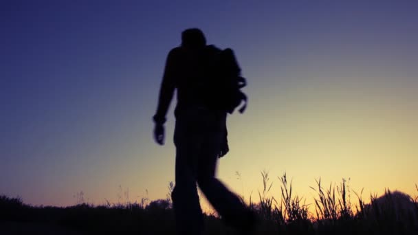 Silhouette dell'uomo cammina in salita contro il cielo — Video Stock