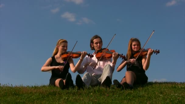 Hombre y mujer tocando violonchelos en la colina — Vídeos de Stock