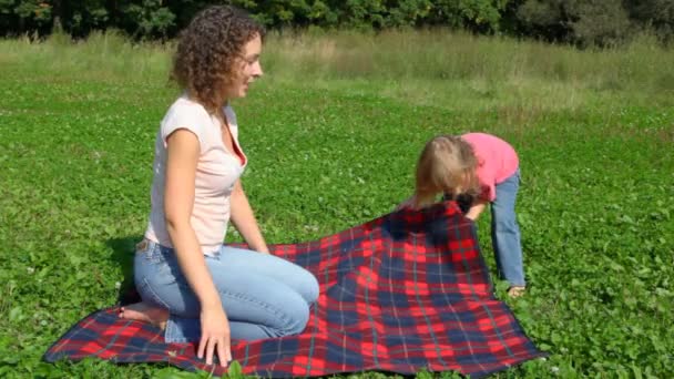 Menina olha de cabeça para baixo entre as pernas e a jovem no parque — Vídeo de Stock
