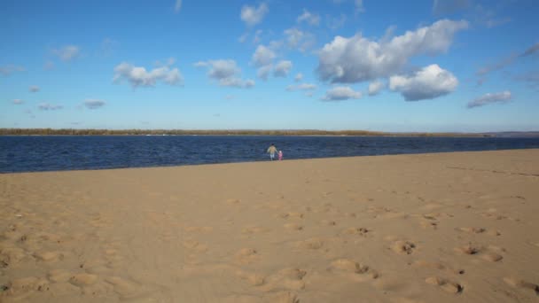 Мужчина и девушка бегают по песчаному пляжу — стоковое видео