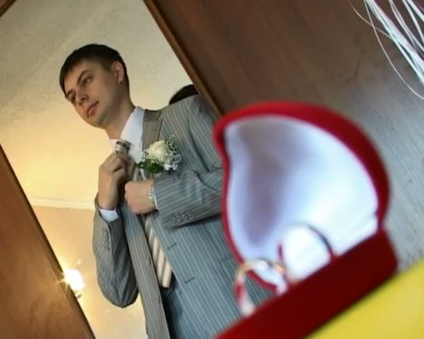 Focusing from groom readjusting his tie to box with wedding rings — Stock Video