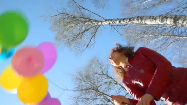 Bande de ballons agitant par femme heureuse dans le parc de printemps, vue vers le bas — Video