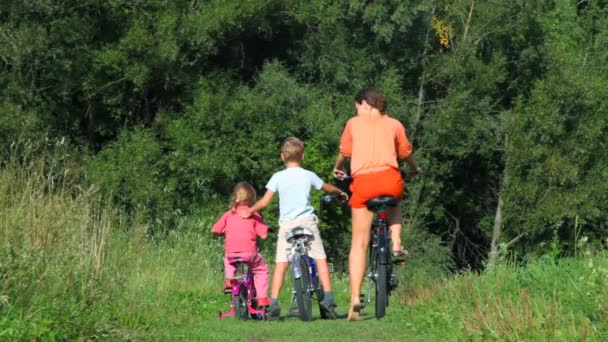 Família de três com bicicletas no campo — Vídeo de Stock