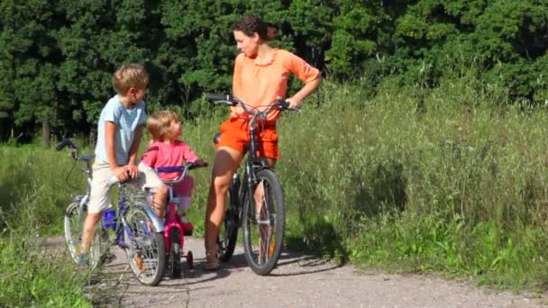 Familia de tres con bicicletas en el campo — Vídeo de stock