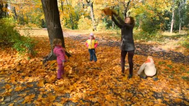 Famille jetant des feuilles dans le parc 