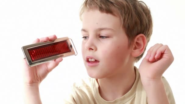 Мальчик в бежевой футболке держит информационный светодиодный дисплей со словом Семья и приносит его на Camcoder — стоковое видео