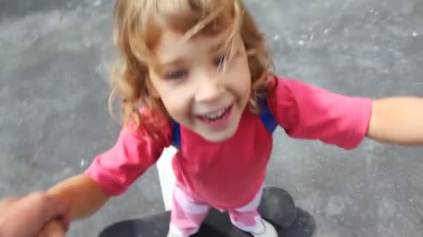 Дівчина стоїть на скейтборді, і він котиться на ньому — стокове відео