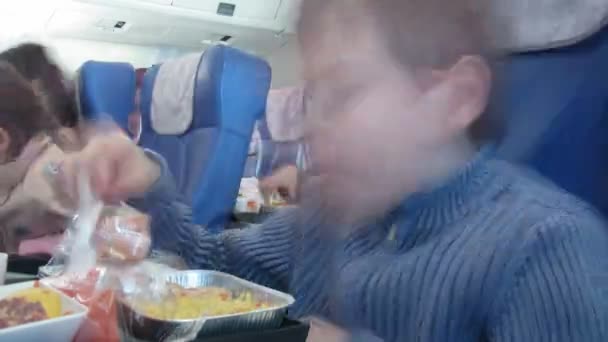 The little serious boy eats in plane salon. Time lapse. — Stock Video