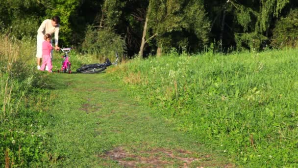 Vater und Mädchen gehen Hand in Hand zu Fahrrädern — Stockvideo