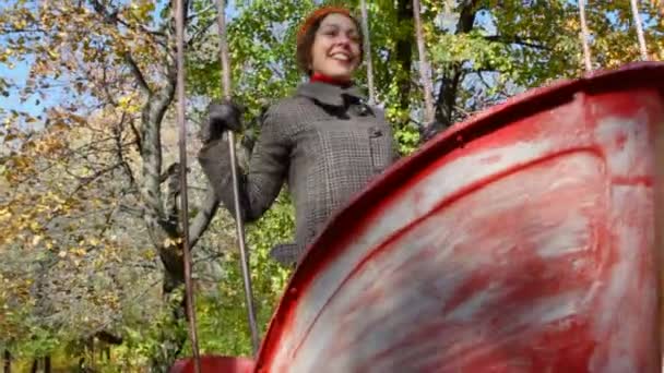 Kadın parkta salıncak tekne üzerinde teetering — Stok video