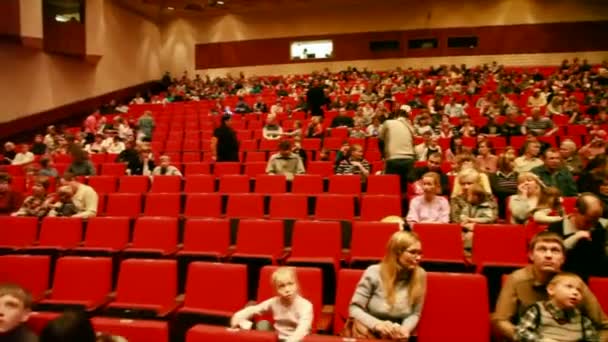 Moskau - 22. Februar: Erwachsene und Kinder sitzen auf roten Stühlen in einem — Stockvideo