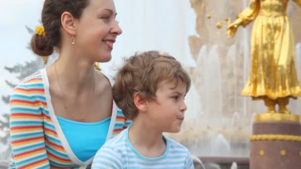 Mor och son sitta nära fountain — Stockvideo