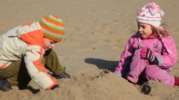 Niño y niña está cavando arena y construyendo edificios — Vídeos de Stock