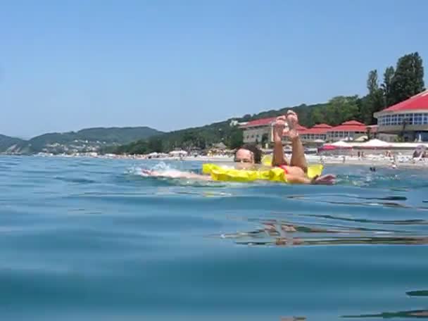 Femme repose sur matelas gonflable et rames dans la mer — Video