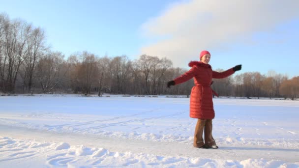 Frau dreht sich im Schneefeld und wirft Schnee — Stockvideo