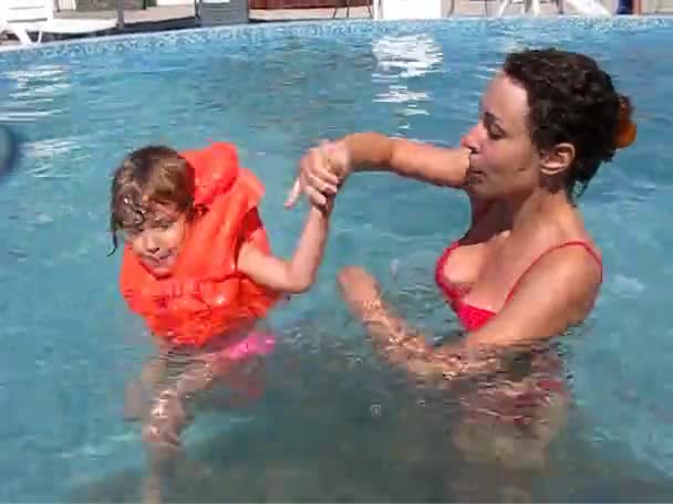 Mère avec fille s'amuse dans la piscine — Video