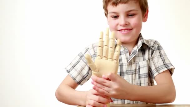 Pojke flexar handled av trä modell av mänsklig hand — Stockvideo