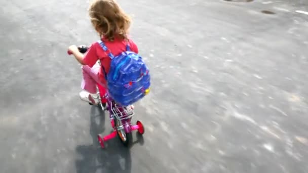 Liten flicka går på fyrhjulig cykel — Stockvideo