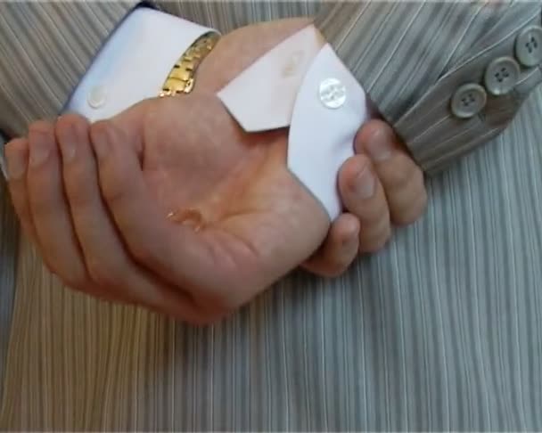 Staande man stak zijn armen achter hem houdt kerk ringen — Stockvideo