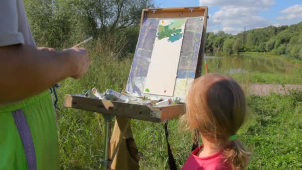 Unbekannter lehrt Mädchen Sommer-Natur malen — Stockvideo