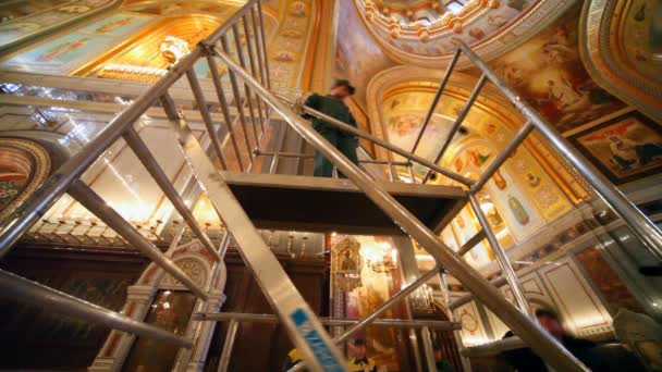 Workers assembles erecting ladder in orthodox cathedral — Stock Video