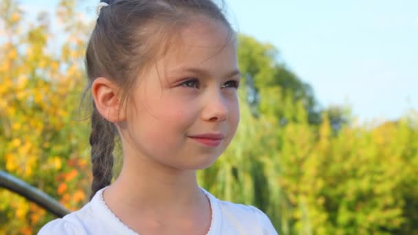 Portret van lachende meisje permanent tegen bomen in park — Stockvideo