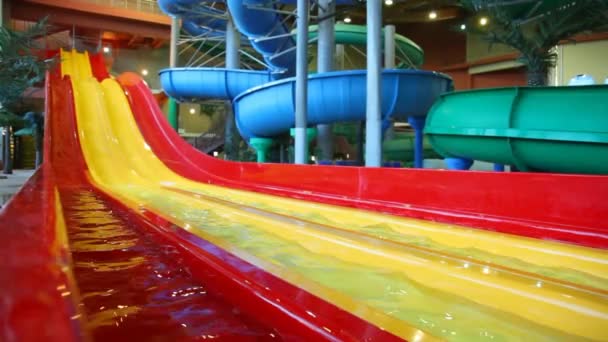 Large yellow plastic slide is filled a water in a large indoor waterpark — Stock Video