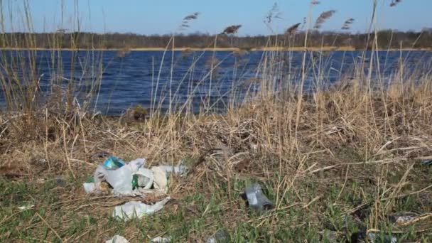 Basura doméstica en la orilla del río contaminada por la primavera — Vídeos de Stock