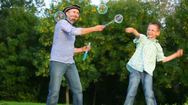 Man in piraat kostuum maakt zeepbellen, jongen ze vernietigt — Stockvideo