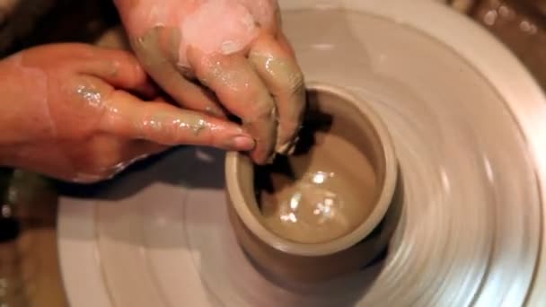Paar handen vormen klei pot op potters wiel — Stockvideo